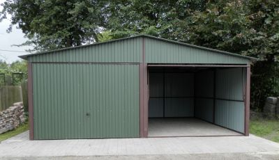 Zbudowany na betonowym podłożu, zielony garaż na dwa stanowiska z jedną otwartą bramą
