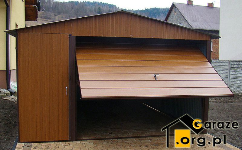 Jasnobrązowy garaż z bramą uchylną i dodatkowymi drzwiami od frontu