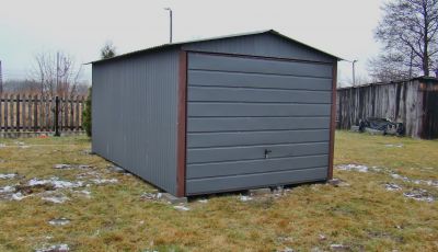 Szary garaż z blachy falistej, stojący na podwórku
